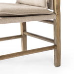 Inspired by a vintage safari-style frame, this dining chair is defined by the fluid strap arms. Semi-attached cushions in taupe performance fabric, finished with button tufting details. Framed out by warm parawood. Amethyst Home provides interior design, new home construction design consulting, vintage area rugs, and lighting in the Omaha metro area.