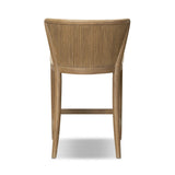 The barrel back counter stool, refreshed. Light oak shapes an armless frame and curved rear legs that almost appear to flow into the seat back. A comfy seat is upholstered in high-performance fabric, while reeding details create a sense of perception play. Amethyst Home provides interior design, new home construction design consulting, vintage area rugs, and lighting in the Kansas City metro area.