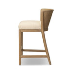The barrel back counter stool, refreshed. Light oak shapes an armless frame and curved rear legs that almost appear to flow into the seat back. A comfy seat is upholstered in high-performance fabric, while reeding details create a sense of perception play. Amethyst Home provides interior design, new home construction design consulting, vintage area rugs, and lighting in the Miami metro area.