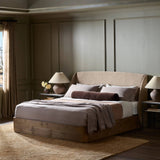 Clean lines meet contoured curves for a timeless bedroom look. A petal-shaped shelter overlaps side rails for a unique,  comforting silhouette. Fully upholstered in a versatile taupe that complements a wide range of color palettes, all grounded by a rich oak base Amethyst Home provides interior design, new home construction design consulting, vintage area rugs, and lighting in the Austin metro area.