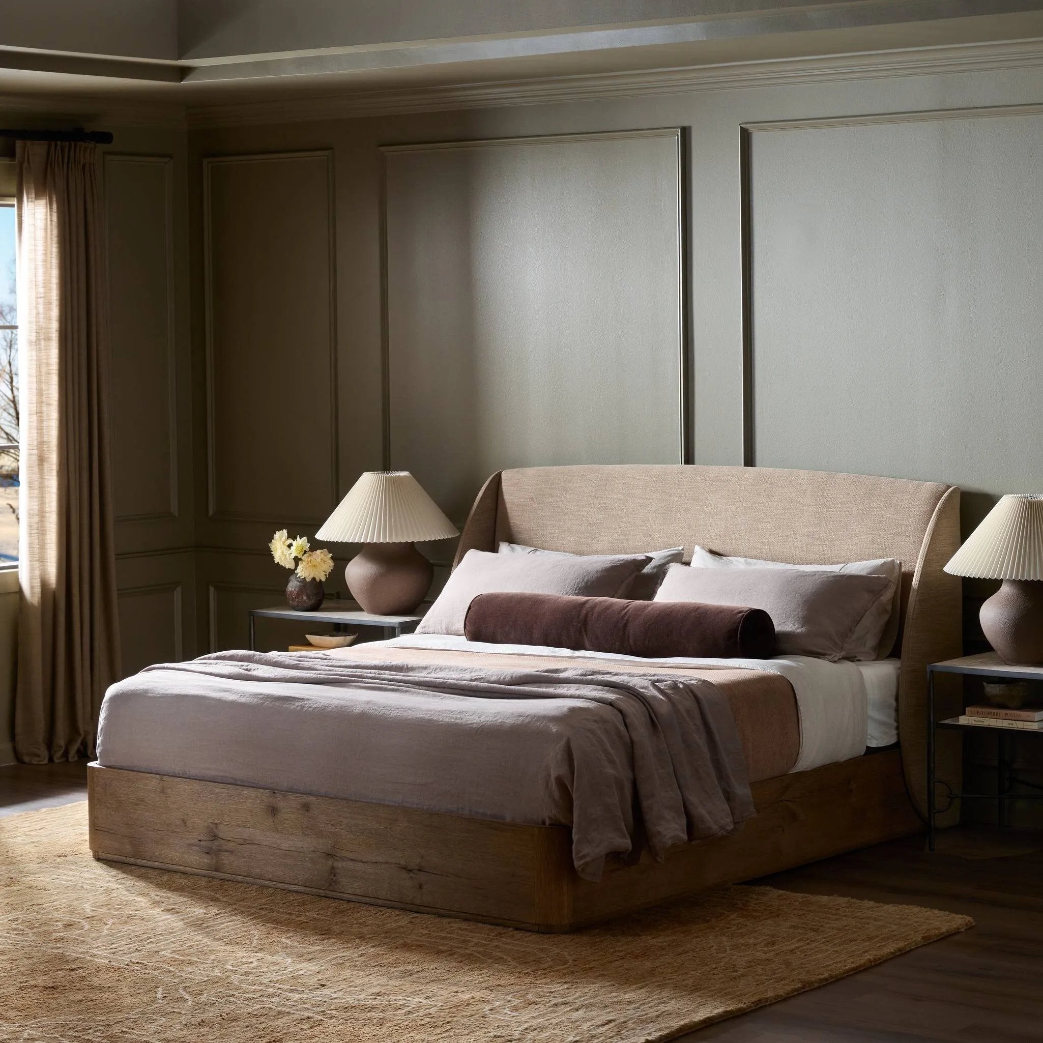 Clean lines meet contoured curves for a timeless bedroom look. A petal-shaped shelter overlaps side rails for a unique,  comforting silhouette. Fully upholstered in a versatile taupe that complements a wide range of color palettes, all grounded by a rich oak base Amethyst Home provides interior design, new home construction design consulting, vintage area rugs, and lighting in the Austin metro area.
