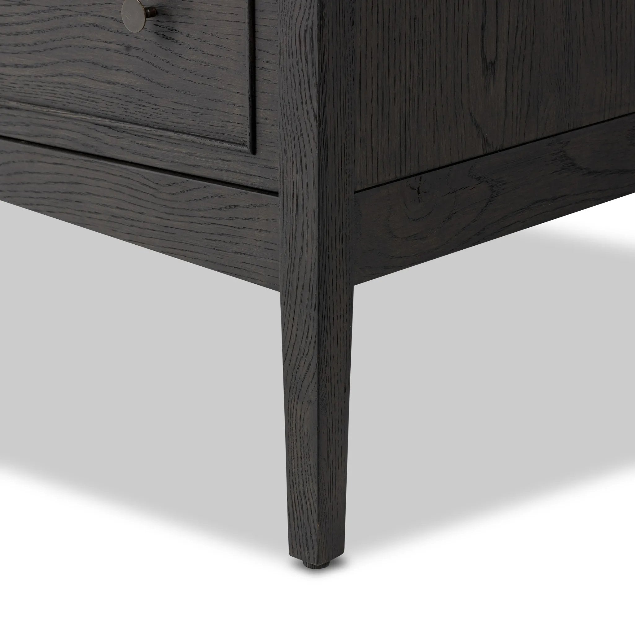 A cleanly shaped six-drawer dresser is crafted from smoked black oak, highlighting the wood's natural grain. Roomy drawers offer plenty of space for bedroom storage, while the slim, tapered legs give the piece a subtle lift, creating a grounded look Amethyst Home provides interior design, new home construction design consulting, vintage area rugs, and lighting in the Des Moines metro area.