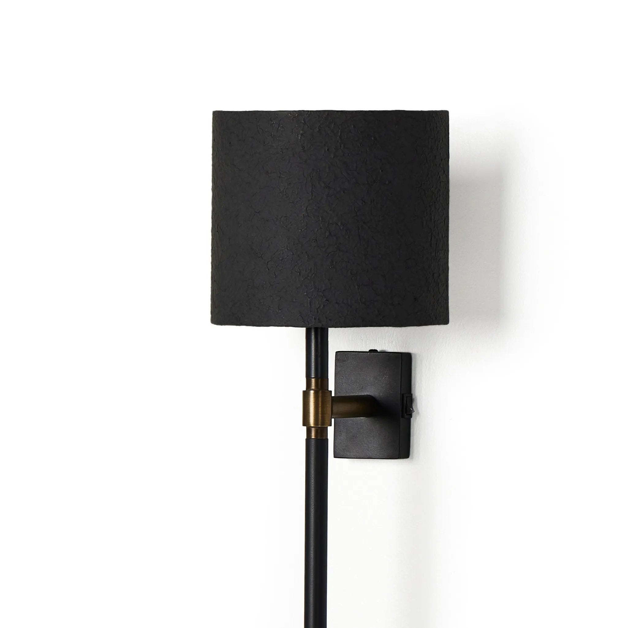 Housed behind a curved black shade, light beams with a soft glow both upward and downward from this plug-in sconce.  A  slim pole to hide the cord and a convenient switch on the backplate create a seamless look Amethyst Home provides interior design, new home construction design consulting, vintage area rugs, and lighting in the Kansas City metro area.