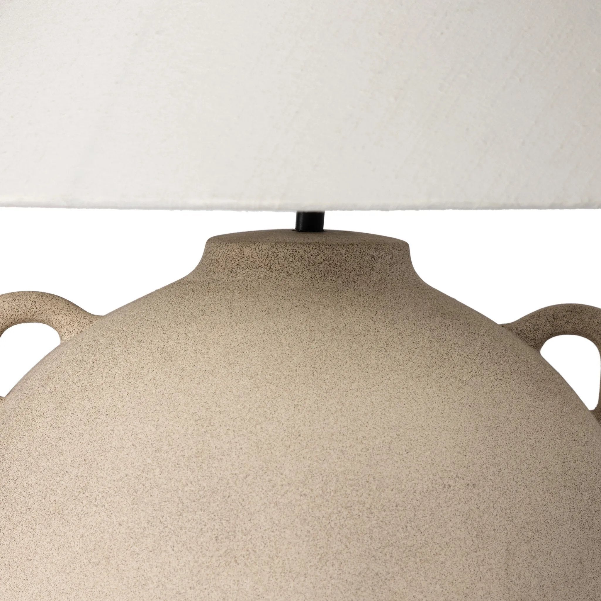 Featuring Mays Light Sand Porcelain Table Lamp by Four Hands at Amethyst Home. Inspired by vintage clay jars, a light sand-colored talavera lamp with handle-like detailing pairs with a tapered linen shade in a versatile ivory. Overall Dimensions: 22.00"w x 22.00"d x 21.00"h
 Shop this lamp at Amethyst - https://www.amethysthome.com/products/mays-light-sand-po. Amethyst Home provides interior design, new home construction design consulting, vintage area rugs, and lighting in the Houston metro area.