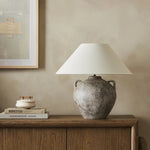 Inspired by vintage clay jars, a brown talavera lamp with handle-like detailing pairs with a tapered linen shade in a versatile ivory Amethyst Home provides interior design, new home construction design consulting, vintage area rugs, and lighting in the Miami metro area.