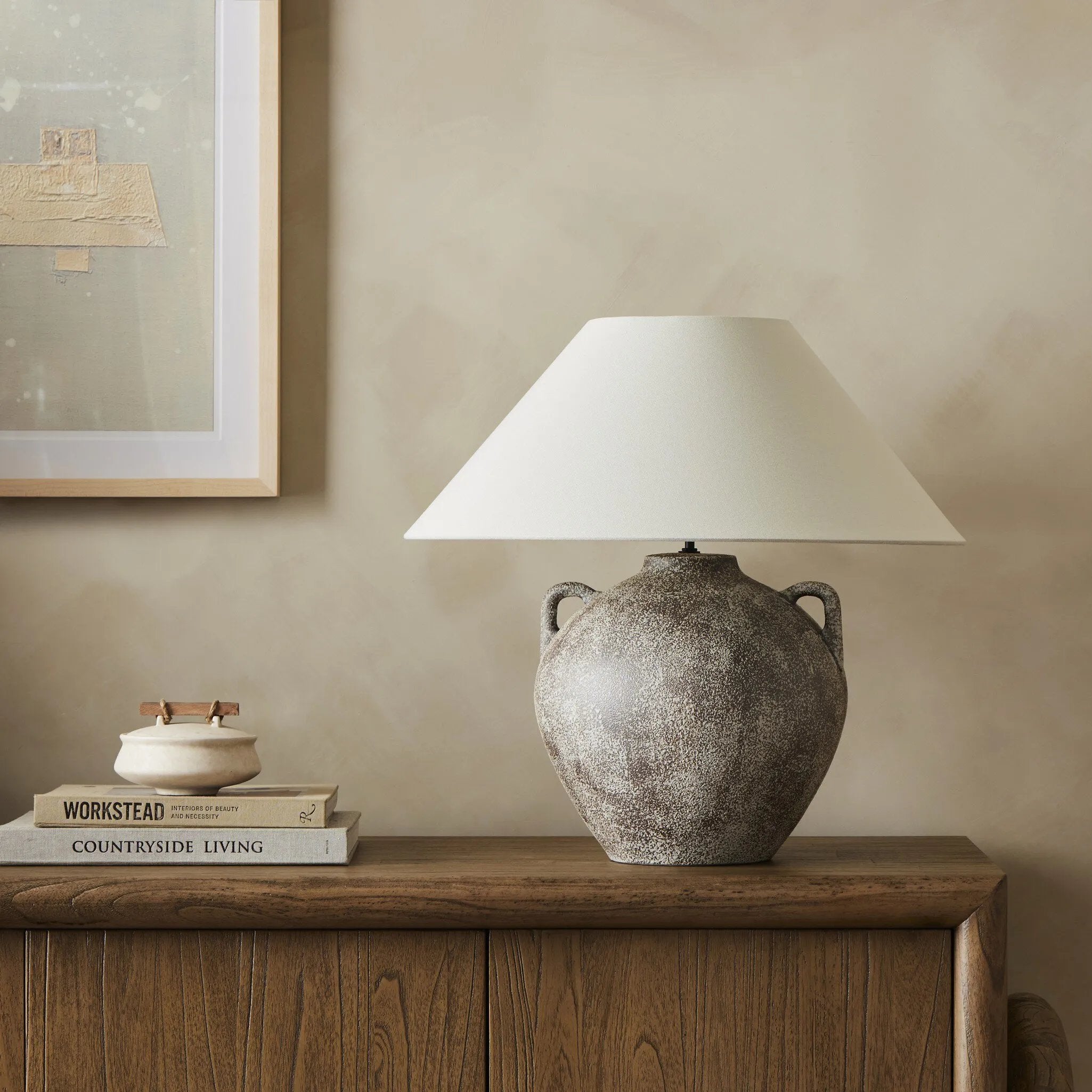Inspired by vintage clay jars, a brown talavera lamp with handle-like detailing pairs with a tapered linen shade in a versatile ivory Amethyst Home provides interior design, new home construction design consulting, vintage area rugs, and lighting in the Miami metro area.