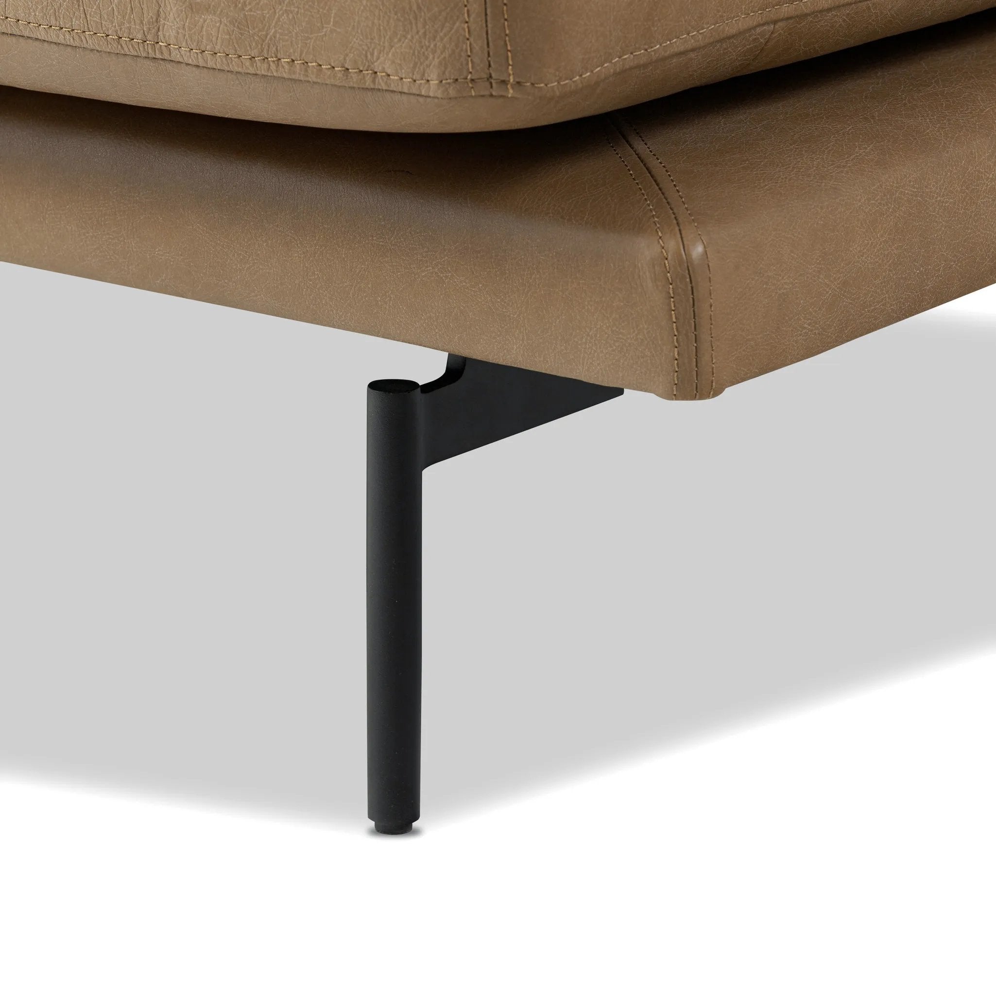 A minimalist sectional to redefine contemporary lounging. Made from tan top-grain leather with a slim profile, expert tailoring and plush cushions for comfort. Sleek metal legs and compact sizing make this piece a versatile anchor for smaller living spaces Amethyst Home provides interior design, new home construction design consulting, vintage area rugs, and lighting in the Houston metro area.