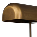 A library task light brings focused illumination to your workspace, nightstand or end table. Crafted from brass with an aged antique finish, the lamp has a rotary switch on the base and double post arms to hold the metal shade in place Amethyst Home provides interior design, new home construction design consulting, vintage area rugs, and lighting in the Omaha metro area.
