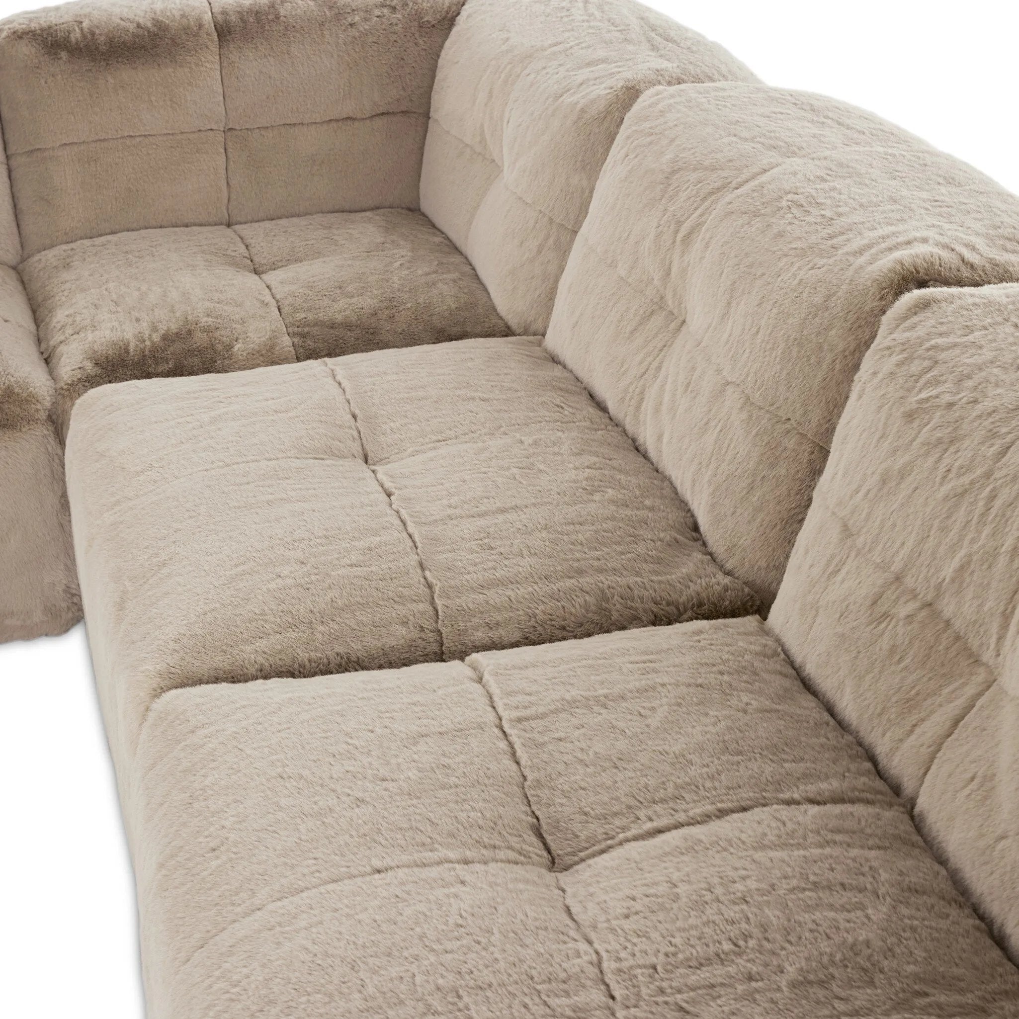 Modularity at its best, and softest. This versatile sectional includes seven pieces crafted with soft cushioning and S-spring suspension for a supportive sit. All covered in a plush, furry fabric that feels luxurious to sink into. Discreet seams add a touch of structure throughout Amethyst Home provides interior design, new home construction design consulting, vintage area rugs, and lighting in the Houston metro area.