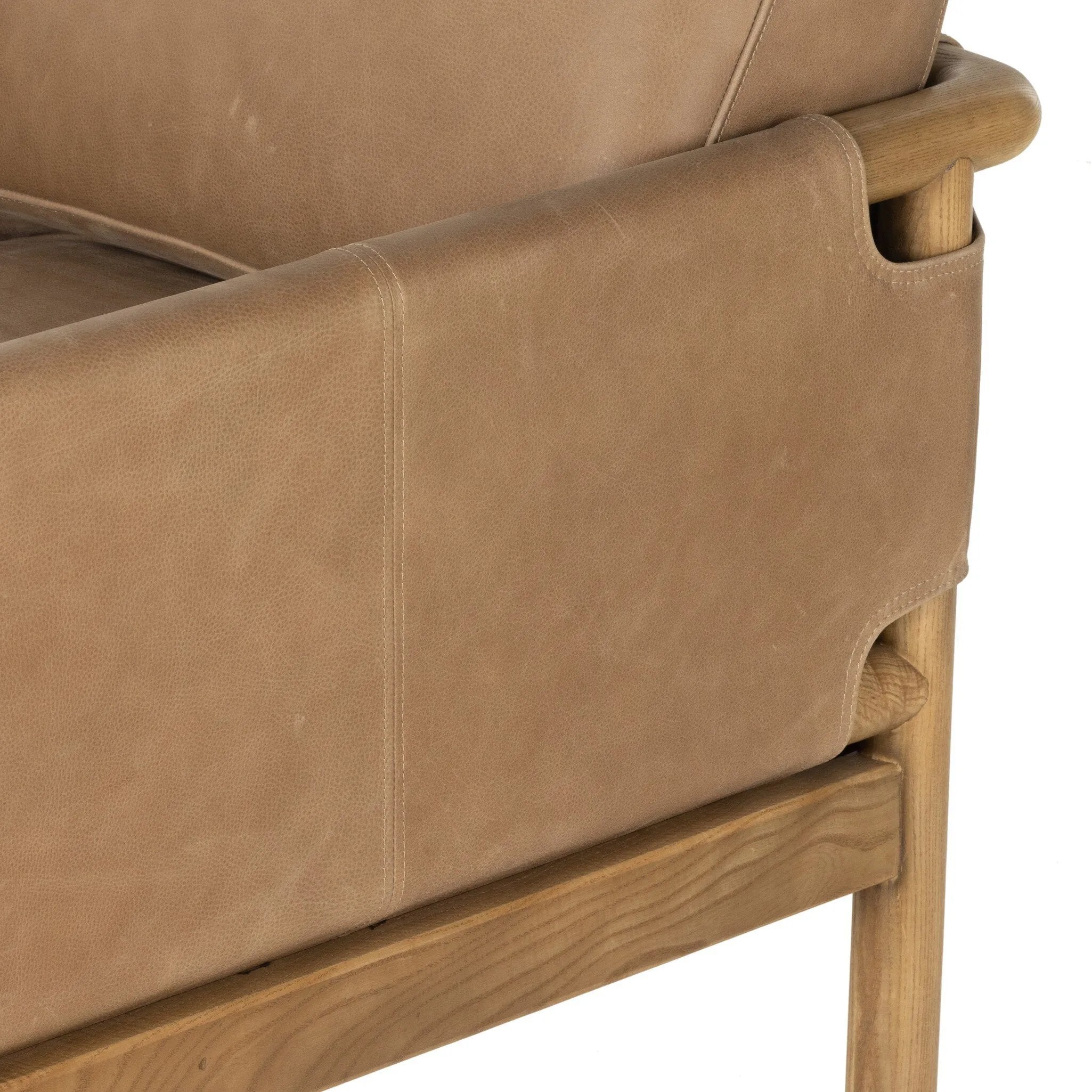 Safari inspiration meets zen aspirations. A cylindrical frame is crafted, smoothed and rounded from solid ash wood. Includes two loose feather-blend cushions covered in subtly distressed thick cut leather in a neutral taupe hue for a monochromatic look Amethyst Home provides interior design, new home construction design consulting, vintage area rugs, and lighting in the Laguna Beach metro area.