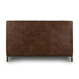 Subtle, modern elegance. A low, tufted headboard in a vintage tobacco faux leather pairs with a simple gunmetal iron base Amethyst Home provides interior design, new home construction design consulting, vintage area rugs, and lighting in the Winter Garden metro area.
