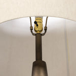 A striking silhouette. An antique brass finish highlights iron's gradual blending of hues for a distinctive ombre effect on this tapered metal base. Topped with a 100% cotton shade Amethyst Home provides interior design, new home construction design consulting, vintage area rugs, and lighting in the Miami metro area.
