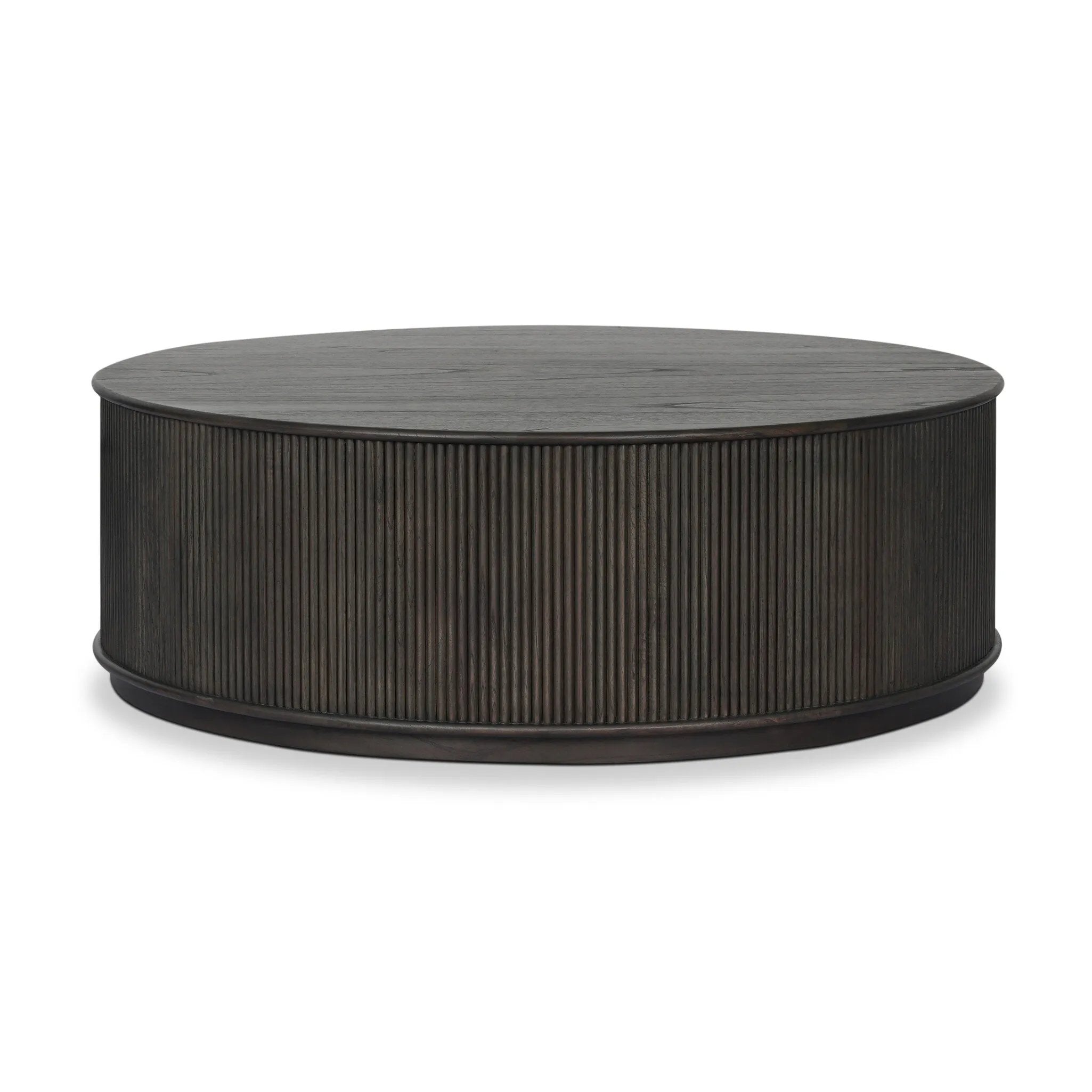 An artisanal take on texture. Made from black-finished mindi with a plinth-style base, a reeding pattern is carved around the entirety of this coffee table table for a fresh, approachable look.As fans of clean style at Amethyst, we love the nature inspired Ona Coffee Table - Smoked Black Mindi - Smoked Black Mindi Veneer. Amethyst Home provides interior design, new home construction design consulting, vintage area rugs, and lighting in the Houston metro area.