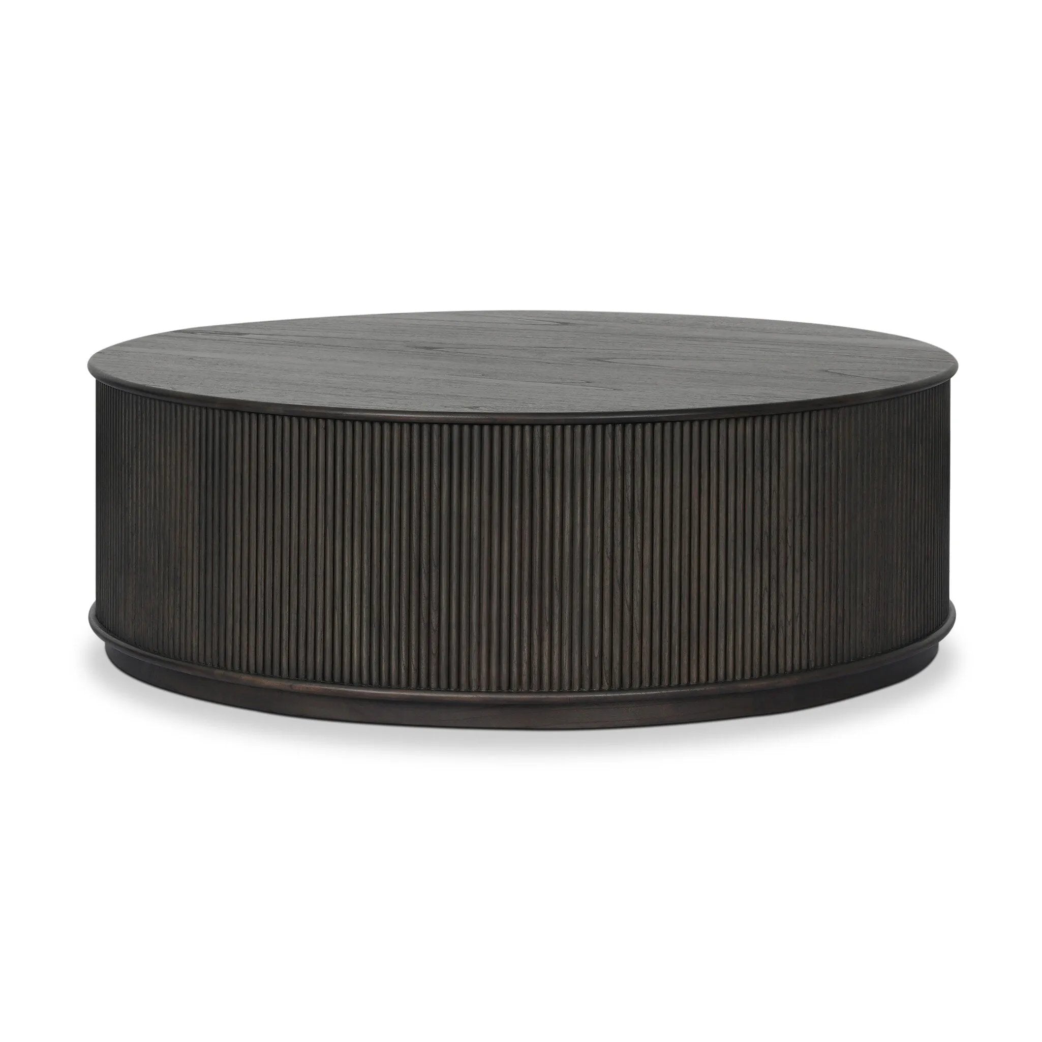 An artisanal take on texture. Made from black-finished mindi with a plinth-style base, a reeding pattern is carved around the entirety of this coffee table table for a fresh, approachable look.As fans of clean style at Amethyst, we love the nature inspired Ona Coffee Table - Smoked Black Mindi - Smoked Black Mindi Veneer. Amethyst Home provides interior design, new home construction design consulting, vintage area rugs, and lighting in the Kansas City metro area.