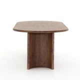 A study in shape. Solid brown acacia forms crescent-shaped legs and sprawling oval tabletop, bringing organic presence to the dining room Amethyst Home provides interior design, new home construction design consulting, vintage area rugs, and lighting in the Houston metro area.
