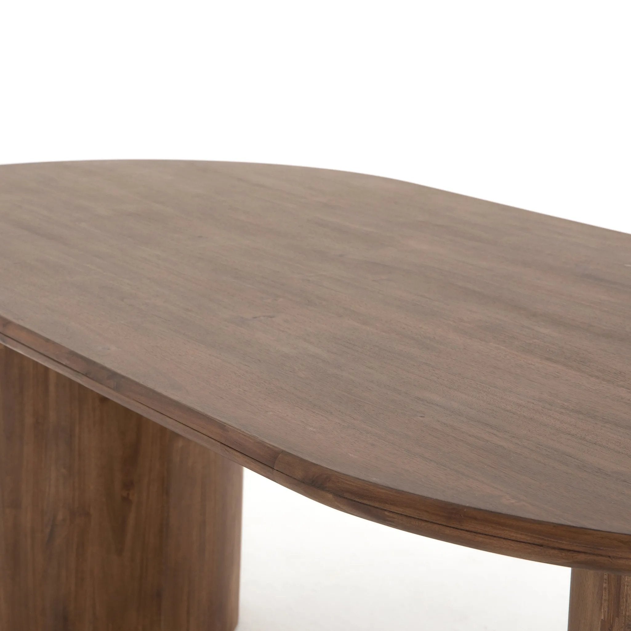 A study in shape. Solid brown acacia forms crescent-shaped legs and sprawling oval tabletop, bringing organic presence to the dining room Amethyst Home provides interior design, new home construction design consulting, vintage area rugs, and lighting in the Kansas City metro area.