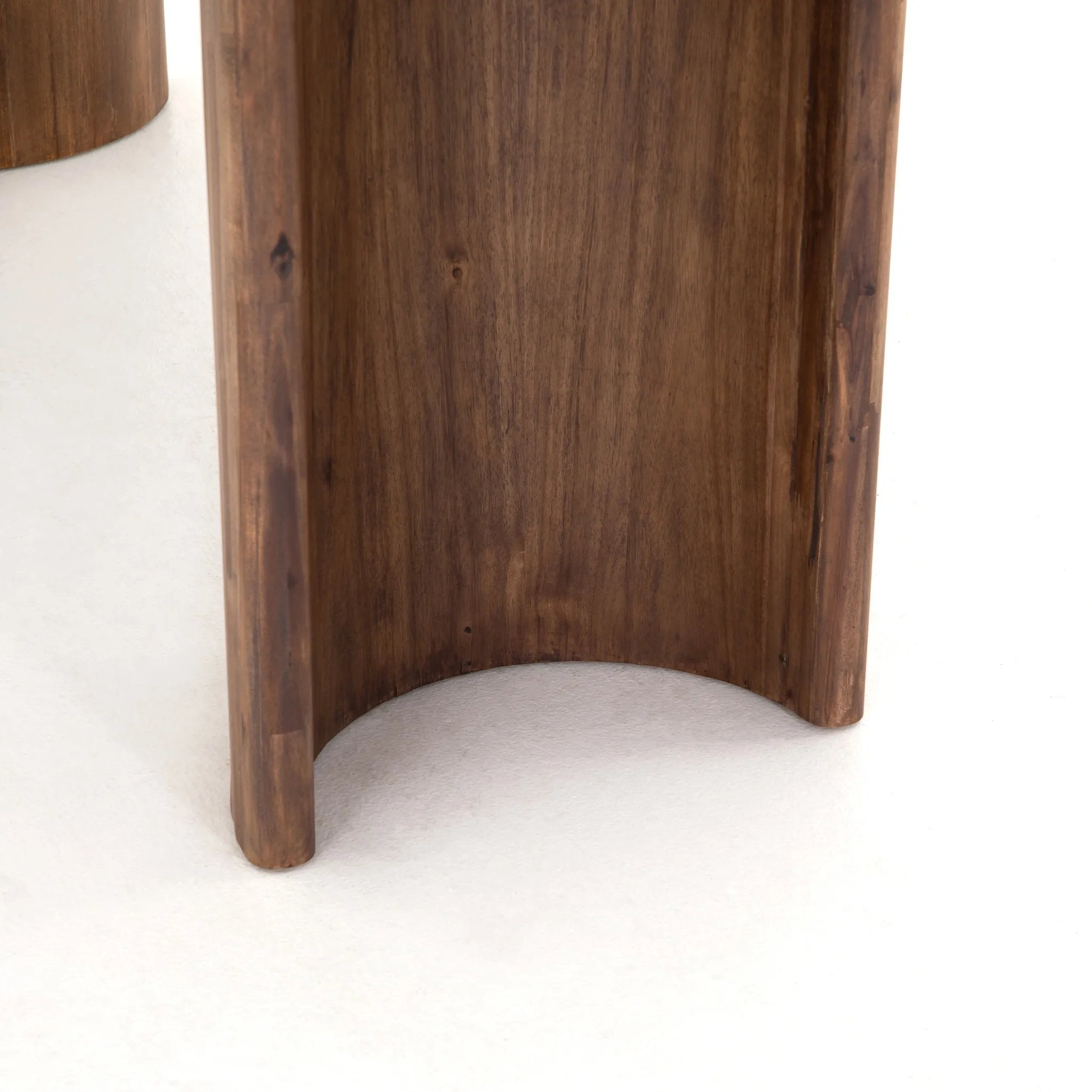 A study in shape. Solid brown acacia forms crescent-shaped legs and sprawling oval tabletop, bringing organic presence to the dining room Amethyst Home provides interior design, new home construction design consulting, vintage area rugs, and lighting in the Miami metro area.