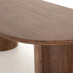 A study in shape. Solid brown acacia forms crescent-shaped legs and sprawling oval tabletop, bringing organic presence to the dining room Amethyst Home provides interior design, new home construction design consulting, vintage area rugs, and lighting in the Nashville metro area.