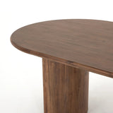 A study in shape. Solid brown acacia forms crescent-shaped legs and sprawling oval tabletop, bringing organic presence to the dining room Amethyst Home provides interior design, new home construction design consulting, vintage area rugs, and lighting in the Tampa metro area.