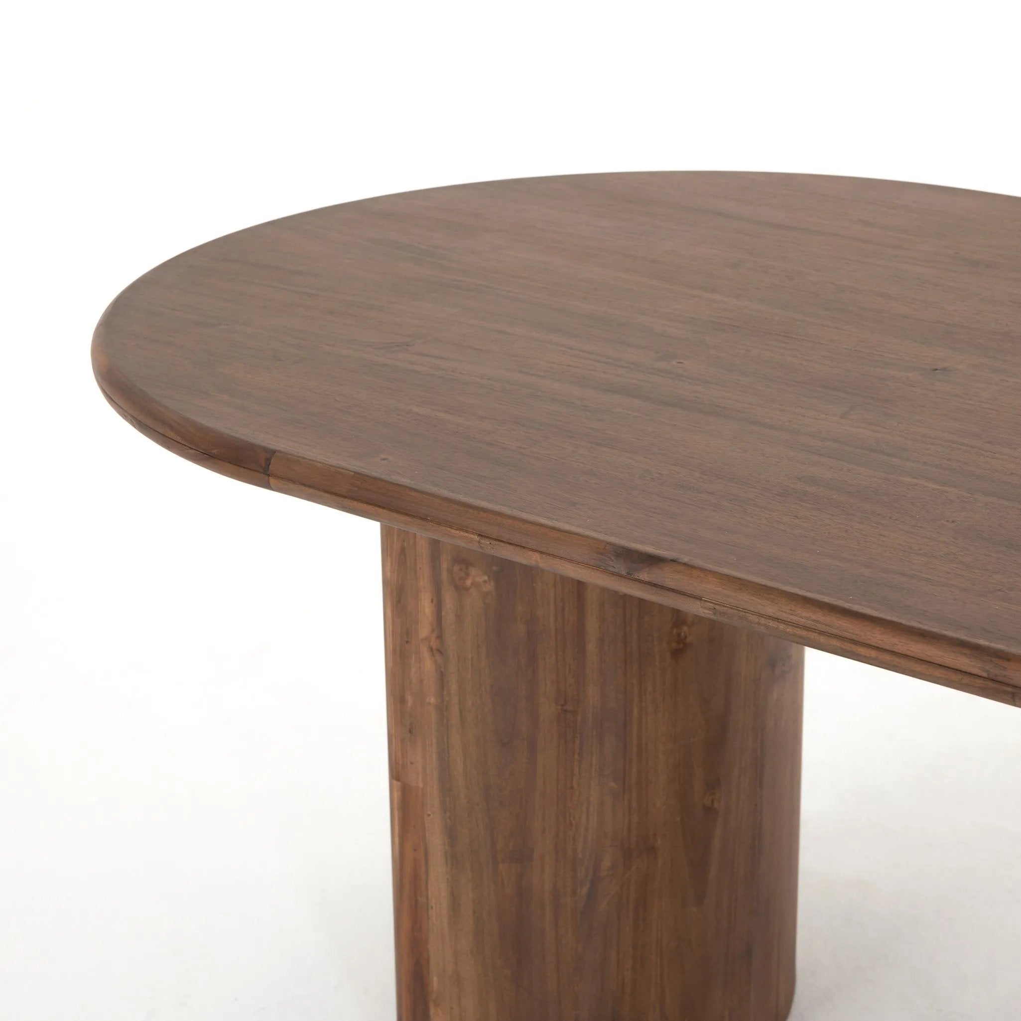 A study in shape. Solid brown acacia forms crescent-shaped legs and sprawling oval tabletop, bringing organic presence to the dining room Amethyst Home provides interior design, new home construction design consulting, vintage area rugs, and lighting in the Tampa metro area.
