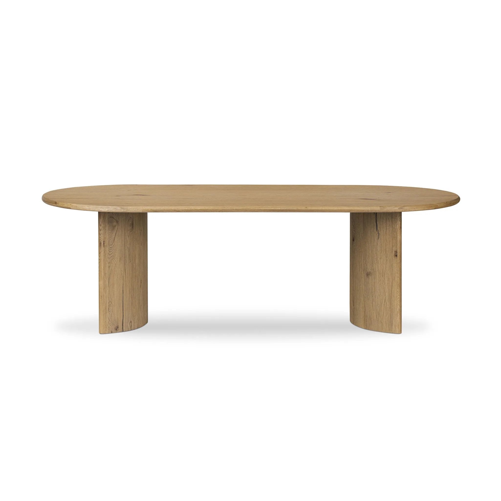 A study in shape. Solid brown oak forms crescent-shaped legs and sprawling oval tabletop, bringing organic presence to the dining room Amethyst Home provides interior design, new home construction design consulting, vintage area rugs, and lighting in the Boston metro area.