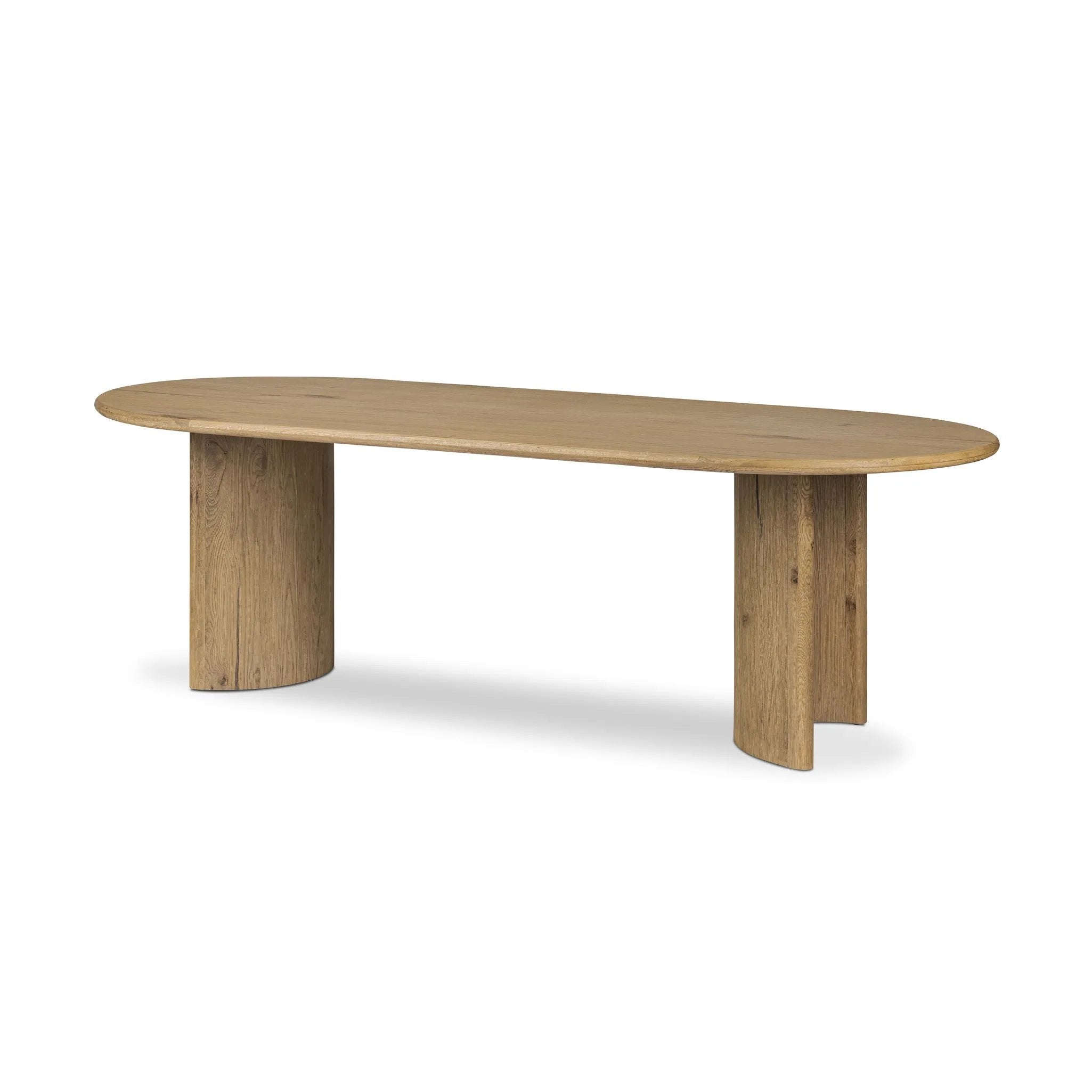 A study in shape. Solid brown oak forms crescent-shaped legs and sprawling oval tabletop, bringing organic presence to the dining room Amethyst Home provides interior design, new home construction design consulting, vintage area rugs, and lighting in the Laguna Beach metro area.