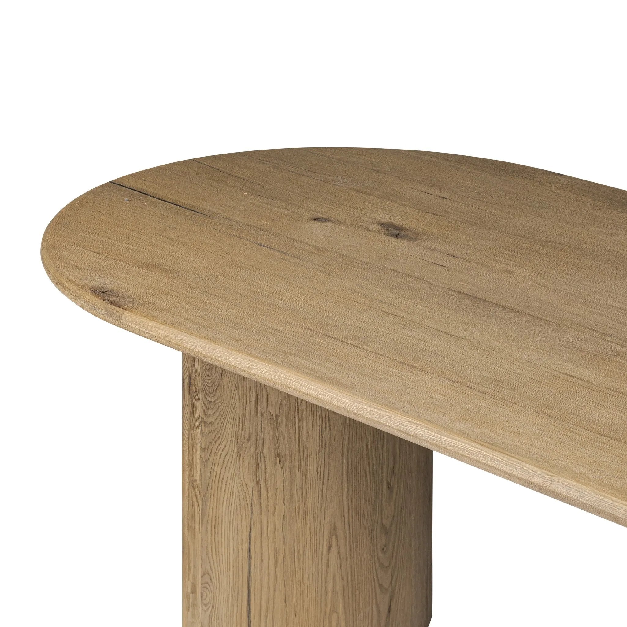 A study in shape. Solid brown oak forms crescent-shaped legs and sprawling oval tabletop, bringing organic presence to the dining room Amethyst Home provides interior design, new home construction design consulting, vintage area rugs, and lighting in the Los Angeles metro area.