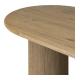 A study in shape. Solid brown oak forms crescent-shaped legs and sprawling oval tabletop, bringing organic presence to the dining room Amethyst Home provides interior design, new home construction design consulting, vintage area rugs, and lighting in the Portland metro area.