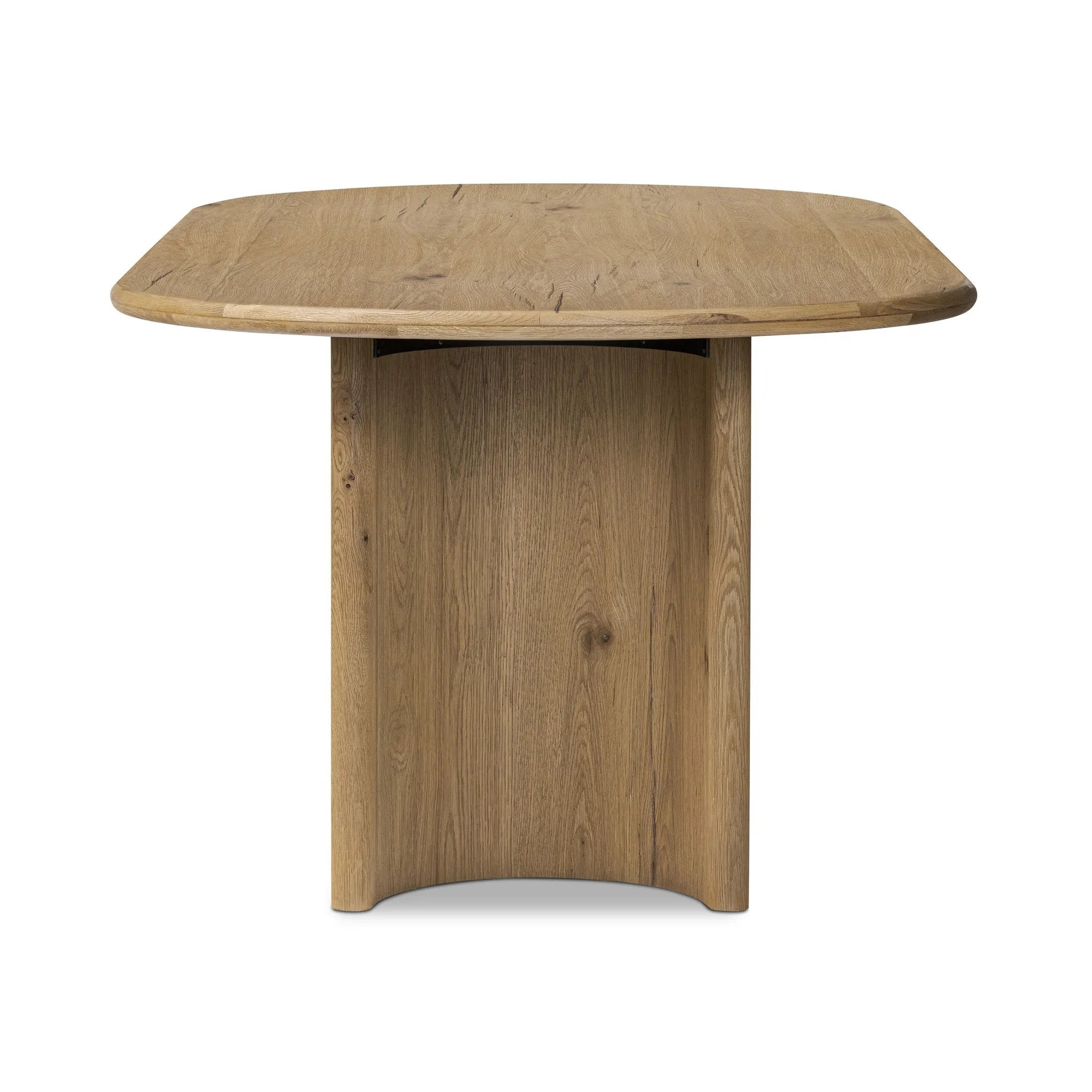 A study in shape. Solid brown oak forms crescent-shaped legs and sprawling oval tabletop, bringing organic presence to the dining room Amethyst Home provides interior design, new home construction design consulting, vintage area rugs, and lighting in the Washington metro area.