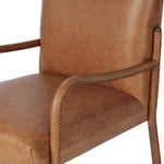 A slim seating style with timeless materials. An armless chair is fully upholstered in butterscotch top-grain leather with a subtle vintage look. Iron legs are also covered in leather, with exposed stitching along each leg. Finished with wooden armrests prime for the head of the table. Amethyst Home provides interior design, new home construction design consulting, vintage area rugs, and lighting in the Seattle metro area.