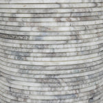 A bold, sculptural presence with movement throughout. This solid marble table features a stacked fluted base and bullnose-edged top that combine to let the natural variation of the material take center stage.As fans of clean design at Amethyst, we love the nature inspired Reeves Dining Table - River Grey Marble. Amethyst Home provides interior design, new home construction design consulting, vintage area rugs, and lighting in the Austin metro area.