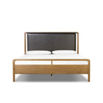 Amber-finished solid oak frames a floating, sling-style headboard made from black top-grain leather, with subtly rounded edges and metal dowel detailing Amethyst Home provides interior design, new home construction design consulting, vintage area rugs, and lighting in the Boston metro area.
