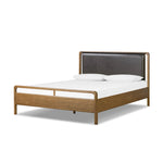 Amber-finished solid oak frames a floating, sling-style headboard made from black top-grain leather, with subtly rounded edges and metal dowel detailing Amethyst Home provides interior design, new home construction design consulting, vintage area rugs, and lighting in the Houston metro area.