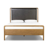 Amber-finished solid oak frames a floating, sling-style headboard made from black top-grain leather, with subtly rounded edges and metal dowel detailing Amethyst Home provides interior design, new home construction design consulting, vintage area rugs, and lighting in the Nashville metro area.