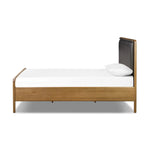 Amber-finished solid oak frames a floating, sling-style headboard made from black top-grain leather, with subtly rounded edges and metal dowel detailing Amethyst Home provides interior design, new home construction design consulting, vintage area rugs, and lighting in the Seattle metro area.
