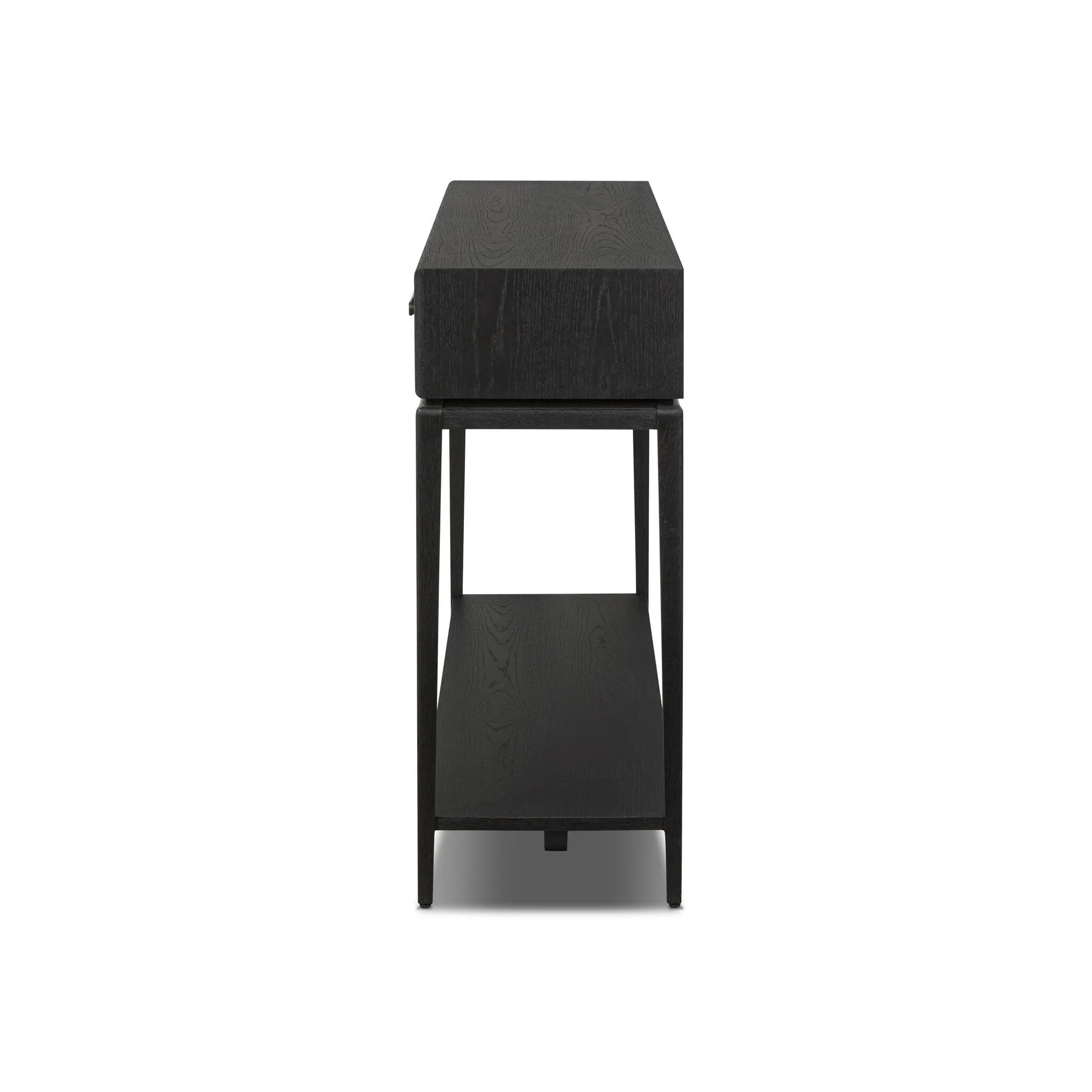 Featuring Rosenell Black Oak Veneer Console Table 60" by Four Hands at Amethyst Home. Elevate your living space or media room with a slim-profile console of black-finished oak. A smooth top pairs with two drawers covered with woven paper cord, while lower open shelving creates bonus storage and display options. The result: a dark, Scandinavian-inspired look. Amethyst Home provides interior design, new home construction design consulting, vintage area rugs, and lighting in the Calabasas metro area.