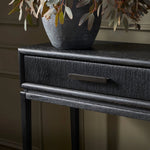 Featuring Rosenell Black Oak Veneer Console Table 60" by Four Hands at Amethyst Home. Elevate your living space or media room with a slim-profile console of black-finished oak. A smooth top pairs with two drawers covered with woven paper cord, while lower open shelving creates bonus storage and display options. The result: a dark, Scandinavian-inspired loo. Amethyst Home provides interior design, new home construction design consulting, vintage area rugs, and lighting in the Washington metro area.