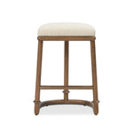 A simple backless stool pairs antique walnut-finished solid ash and high-performance fabric, for a warm, light look. A backless cylinder frame featured tapering for extra stability, with disc-like turning at the bottom for a heritage design detail. Perfectly sized for the counter. Amethyst Home provides interior design, new home construction design consulting, vintage area rugs, and lighting in the Houston metro area.