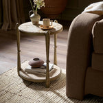 Featuring Ruthie Fossil Marble End Table by Four Hands at Amethyst Home. Work a heritage-inspired piece into your collection with a tiered end table of hammered iron in an aged brass. With inset marble shelves and turn-style legs, this table's fine details bring an elevated, artisan look to any space. Perfectly sized to keep your favorite book or drink on han. Amethyst Home provides interior design, new home construction design consulting, vintage area rugs, and lighting in the Houston metro area.