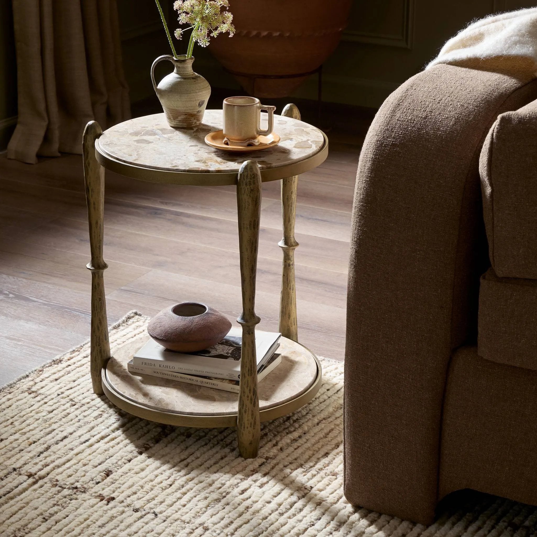 Featuring Ruthie Fossil Marble End Table by Four Hands at Amethyst Home. Work a heritage-inspired piece into your collection with a tiered end table of hammered iron in an aged brass. With inset marble shelves and turn-style legs, this table's fine details bring an elevated, artisan look to any space. Perfectly sized to keep your favorite book or drink on han. Amethyst Home provides interior design, new home construction design consulting, vintage area rugs, and lighting in the Houston metro area.