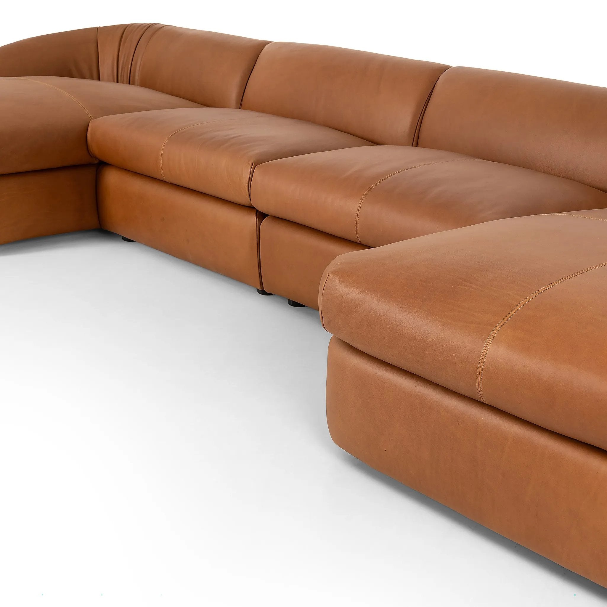 Soft, supple top-grain leather with a warm cognac hue meets vintage vibes with modern comfort. Intricate rouching along the back and corners gives each piece of this four-piece sectional a handcrafted, tailored feel, while feather-wrapped cushioning and spring suspension invite comfortable lounging Amethyst Home provides interior design, new home construction design consulting, vintage area rugs, and lighting in the Austin metro area.