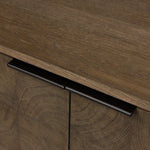Grounding and stunning. We paired a modern frame and chunky base with door panels featuring oyster cuts of oak that take a specialized skill to create. Each cut captures the story of the wood and brings a natural, organic rhythm to the entire sideboard, and any space. Amethyst Home provides interior design, new home construction design consulting, vintage area rugs, and lighting in the Newport Beach metro area.