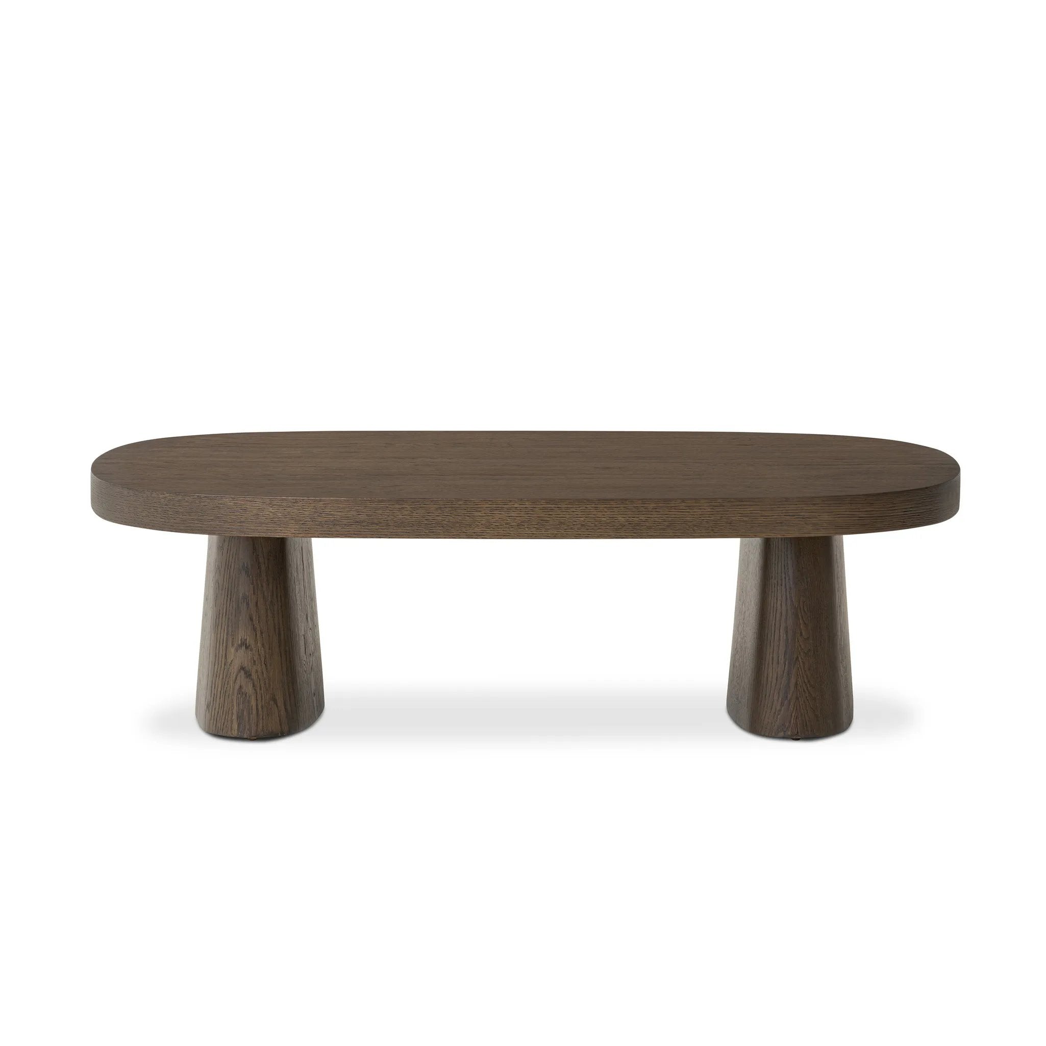 Made from rustic brown oak, a rectangular coffee table is streamlined while not short on presence, with its exaggerated cylinder legs and polished pill-shaped top Amethyst Home provides interior design, new home construction design consulting, vintage area rugs, and lighting in the Los Angeles metro area.