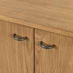 Simple yet refined, a Danish design-influenced sideboard is made from light-finished ash, with iron hardware finished in a sleek gunmetal. Perfect for larger spaces, with six doors and generous interior storage. Stretcher-style shelving made from woven paper cord serves up a textural finishing touch. Amethyst Home provides interior design, new home construction design consulting, vintage area rugs, and lighting in the Newport Beach metro area.