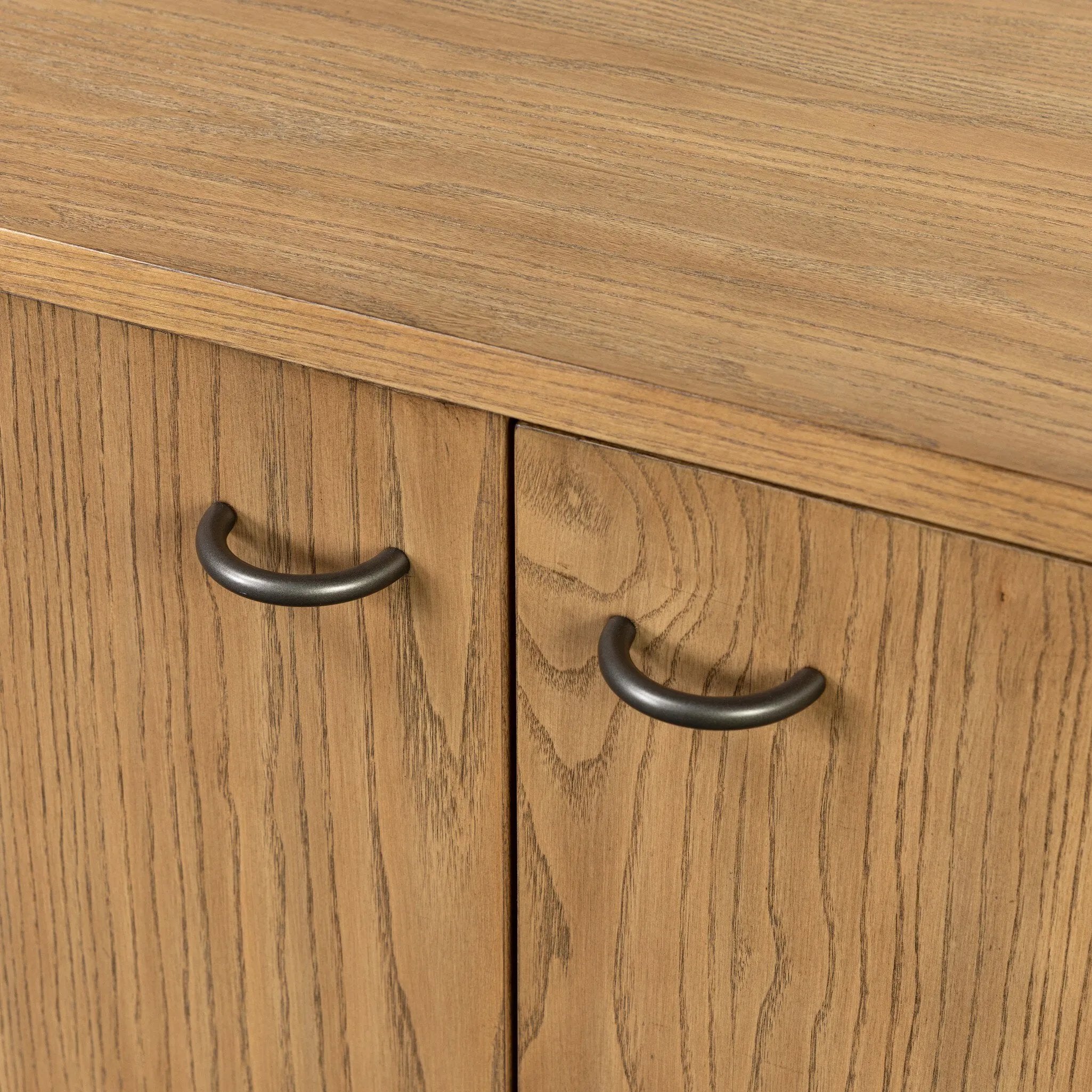 Simple yet refined, a Danish design-influenced sideboard is made from light-finished ash, with iron hardware finished in a sleek gunmetal. Perfect for larger spaces, with six doors and generous interior storage. Stretcher-style shelving made from woven paper cord serves up a textural finishing touch. Amethyst Home provides interior design, new home construction design consulting, vintage area rugs, and lighting in the Newport Beach metro area.