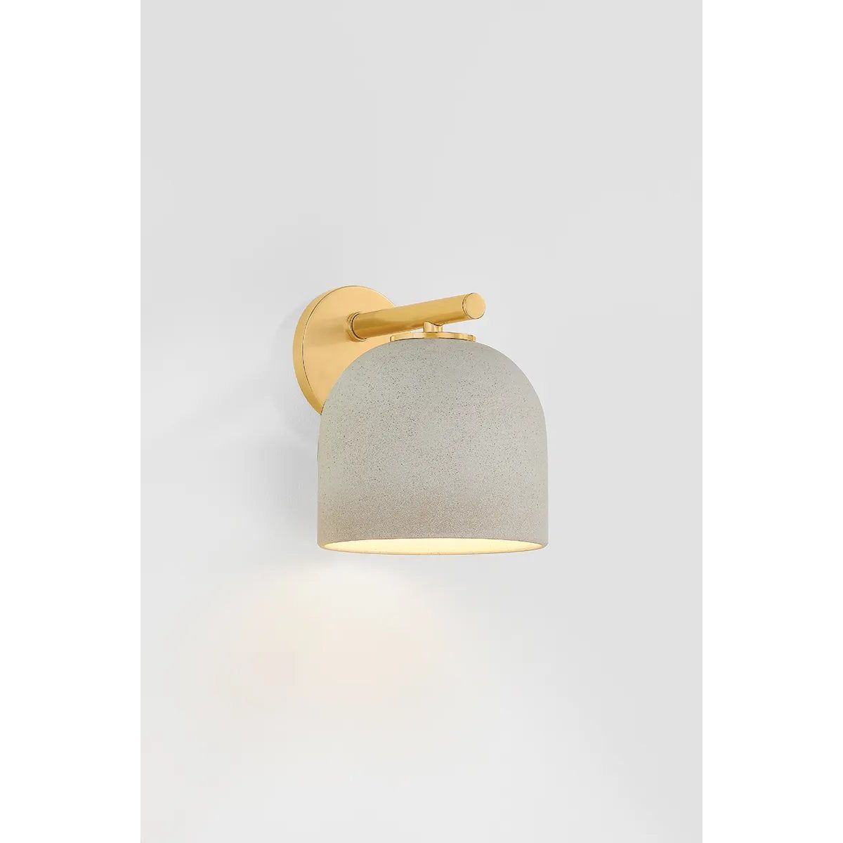 Inspired by Neoclassical architecture, Cara uses a domed shade and textural ceramic finish for a sconce that feels both ancient and new. A matte reactive glaze in an creamy hue creates a subtle surface grain that imitates natural stone. A circular modern armback in an Aged Brass finish adds shine to the fixture.  Amethyst Home provides interior design, new home construction design consulting, vintage area rugs, and lighting in the Los Angeles metro area.