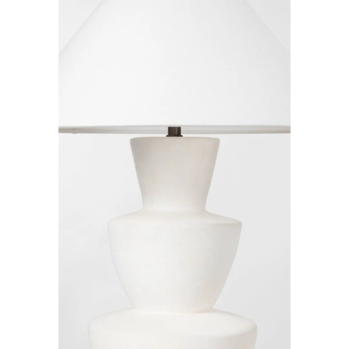 A series of three stacked, bowl-like shapes in ivory texture ceramic give this table lamp an organic, hand-crafted silhouette. The tapered off-white linen shade and Patina Brass accents add to the warm, natural beauty. Amethyst Home provides interior design, new home construction design consulting, vintage area rugs, and lighting in the Kansas City metro area.