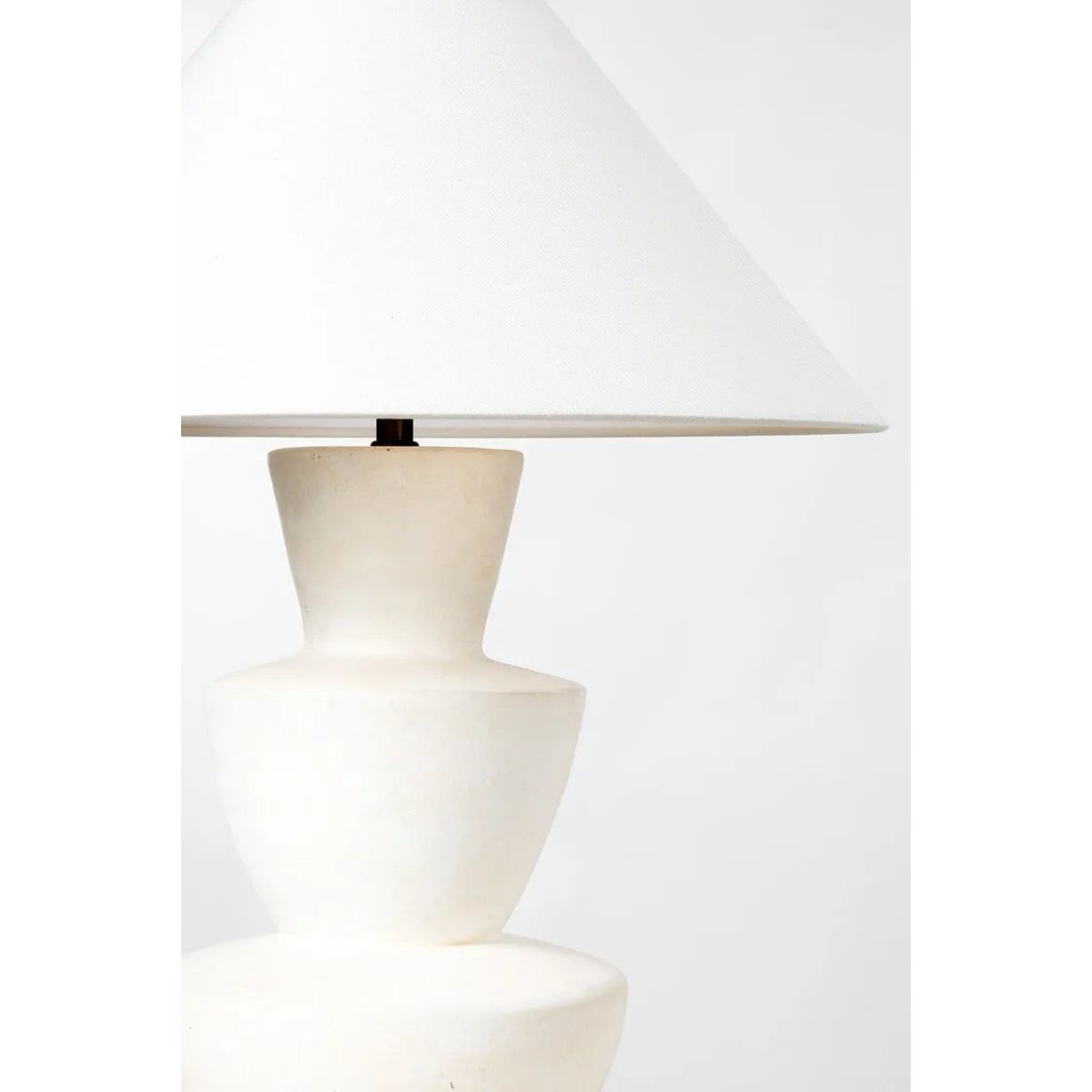 A series of three stacked, bowl-like shapes in ivory texture ceramic give this table lamp an organic, hand-crafted silhouette. The tapered off-white linen shade and Patina Brass accents add to the warm, natural beauty. Amethyst Home provides interior design, new home construction design consulting, vintage area rugs, and lighting in the Nashville metro area.