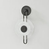 The earring-like design of Keuka Park exudes ornamental, graphic appeal. A thick disc of Blonchino Piastre glass is illuminated at the point where it attaches to the racetrack frame of this striking wall fixture. Whether finished in Aged Brass or Old Bronze, Keuka Park brings modernist artistry to any wall.  Amethyst Home provides interior design, new home construction design consulting, vintage area rugs, and lighting in the Salt Lake City metro area.