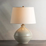 Inspired by rustic pottery, this table lamp's beautifully shaped base is crafted of pale sage ceramic giving it an earthy pale green tone. The off white linen shade pairs naturally and casts a soft glow. Raised seamlines and a reactive glaze that allows hints of the natural ceramic to peek through, give the fixture a hand-thrown, crafted feel. Amethyst Home provides interior design, new home construction design consulting, vintage area rugs, and lighting in the Kansas City metro area.